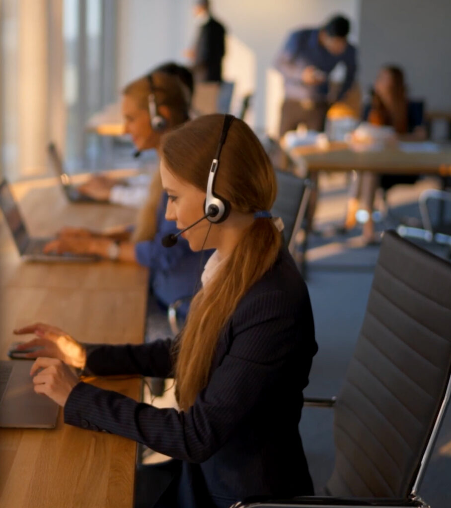 Customer Service reps with headsets and laptops assisting our clients reduce their telecom expense.